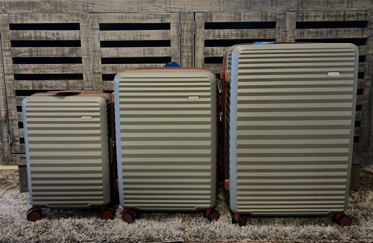 Lineup of three SHOWKOO hardside suitcases on a carpeted floor, showcasing size differences and uniform ribbed PC shell design.