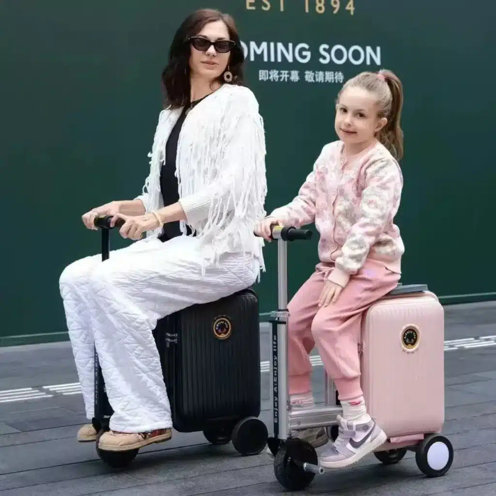 Designer Rideable Electric Luggage Review (20-Inch) 8 Adult and child riding black and pink rideable electric luggage scooters outdoors.