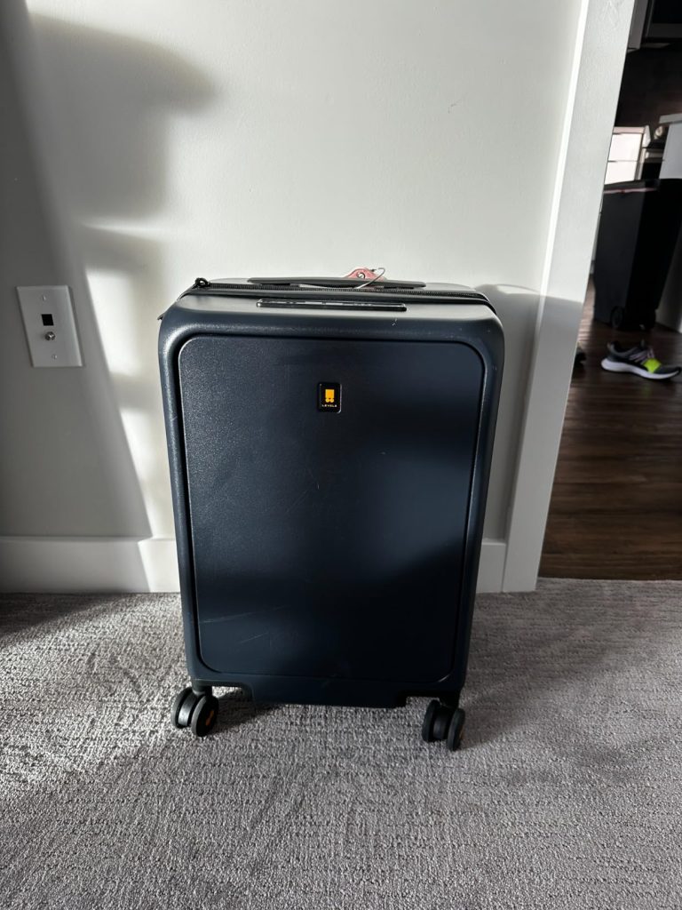 LEVEL8 Road Runner Carry-On standing upright indoors, showing its minimalist matte polycarbonate shell and compact size.