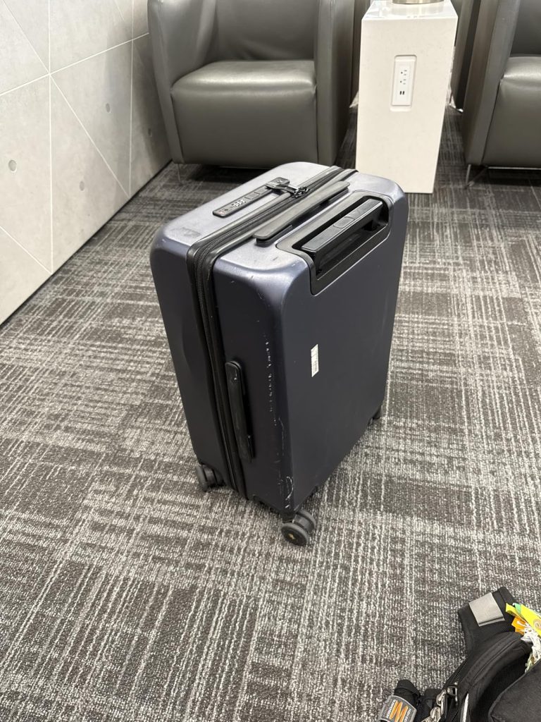 LEVEL8 Road Runner Carry-On Review: A Smart Tech Travel Suitcase 6 LEVEL8 Road Runner Carry-On in an airport lounge, displaying light scuff marks from travel on its durable Makrolon® shell.