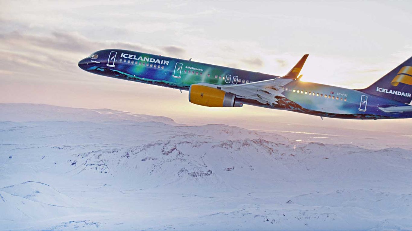 Icelandair aircraft flying over snowy Iceland landscape during a transatlantic flight