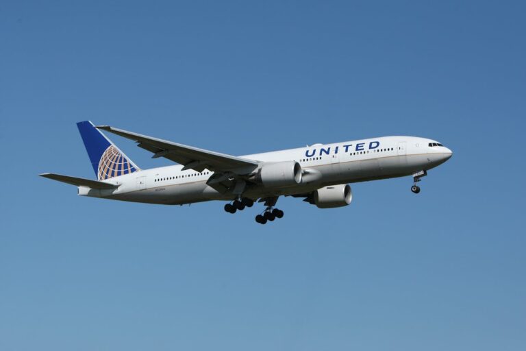 United Airlines passenger airplane flying in clear blue sky during approach for landing