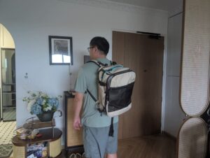 Person wearing the Blast Pro 40L travel backpack indoors to demonstrate real-world size and fit