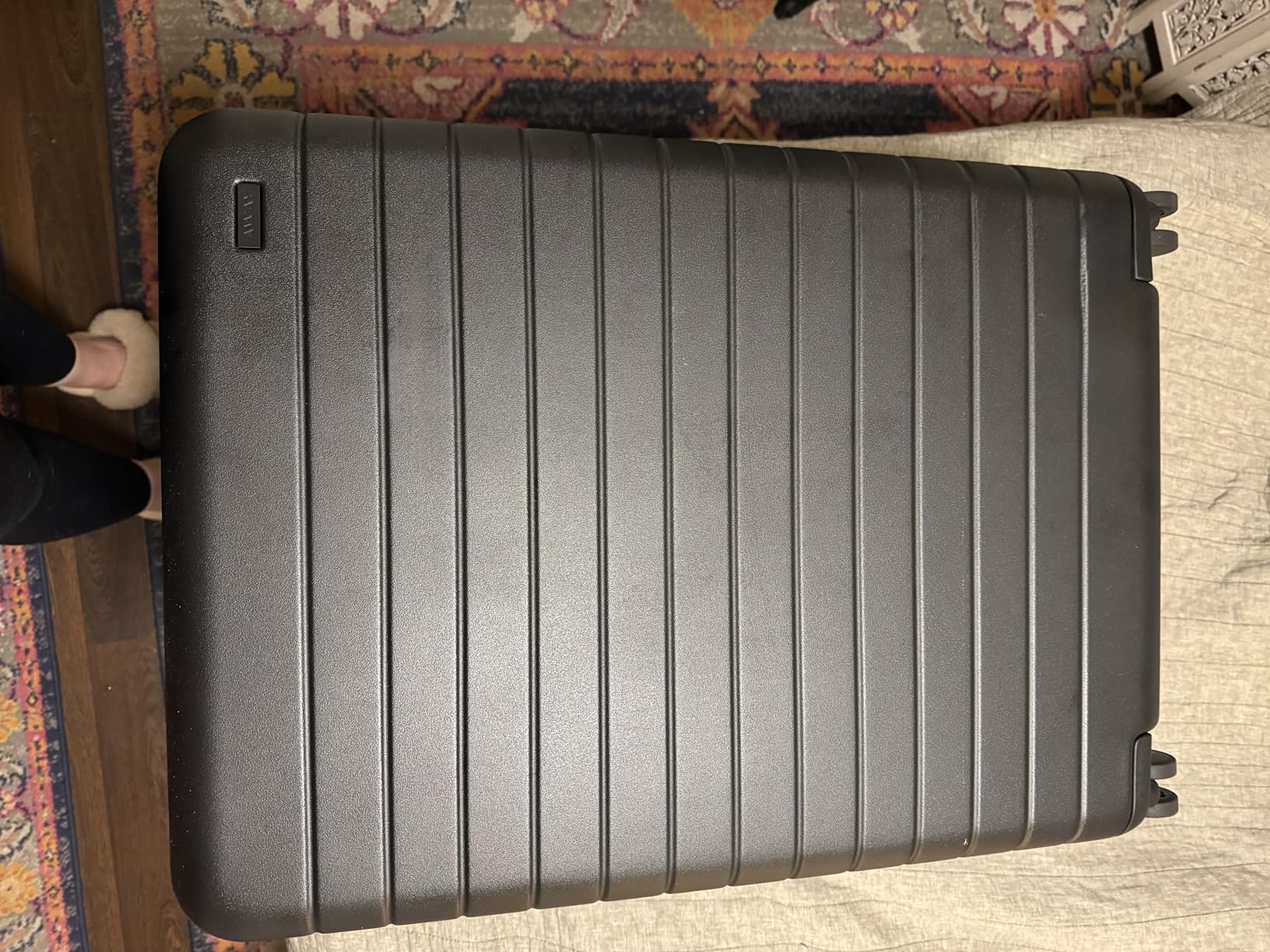 Away Amazon Exclusive Medium Checked Luggage in matte black featuring a durable polycarbonate hard shell with horizontal ridges, photographed from above.