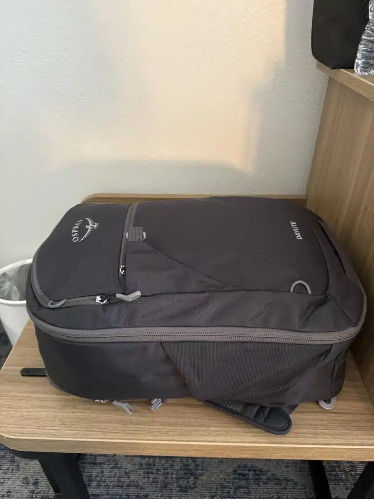 Black Osprey Daylite Carry-On Travel Pack 35L packed and resting on a hotel room table